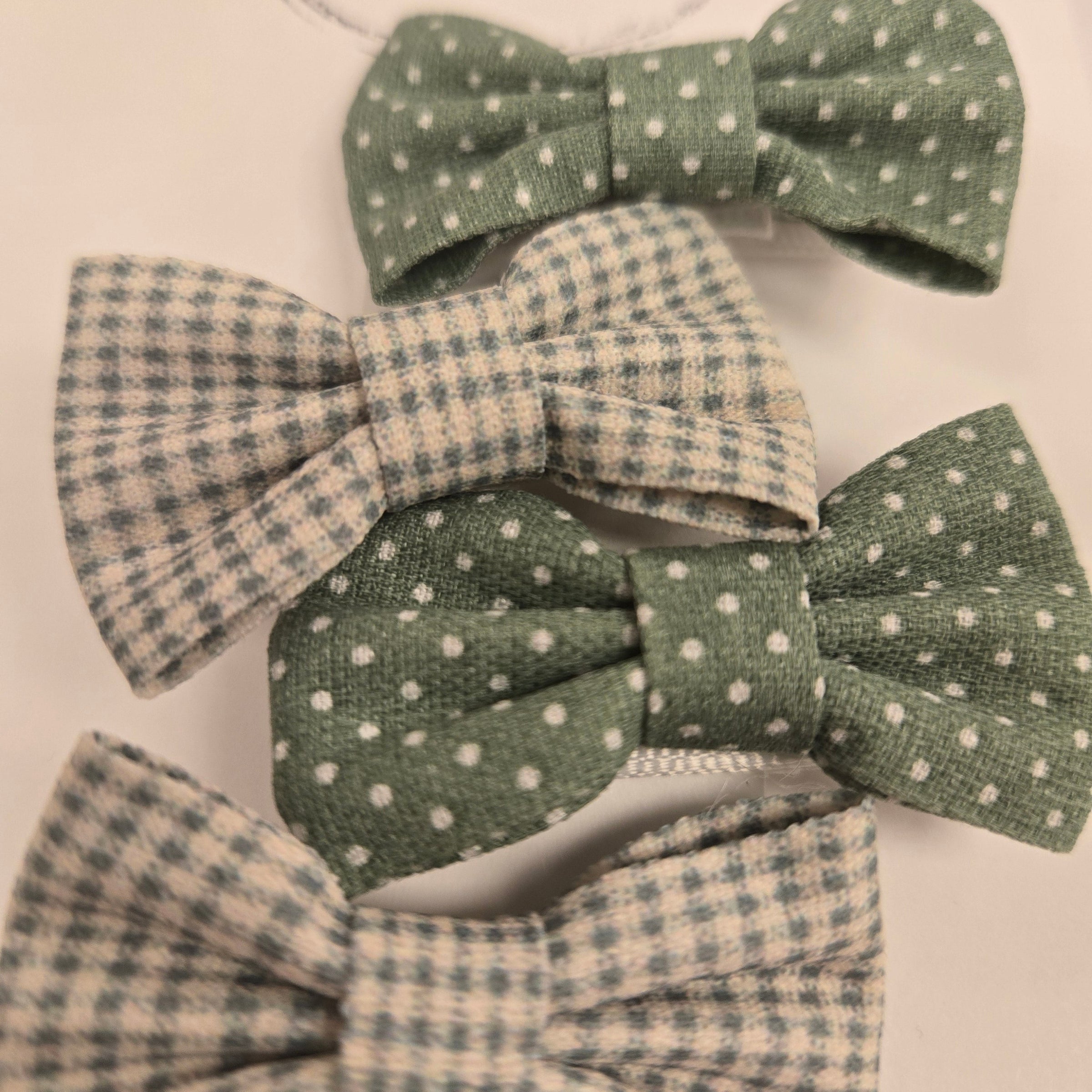 Four fabric bows with polka dot and checkered patterns on a cream background.