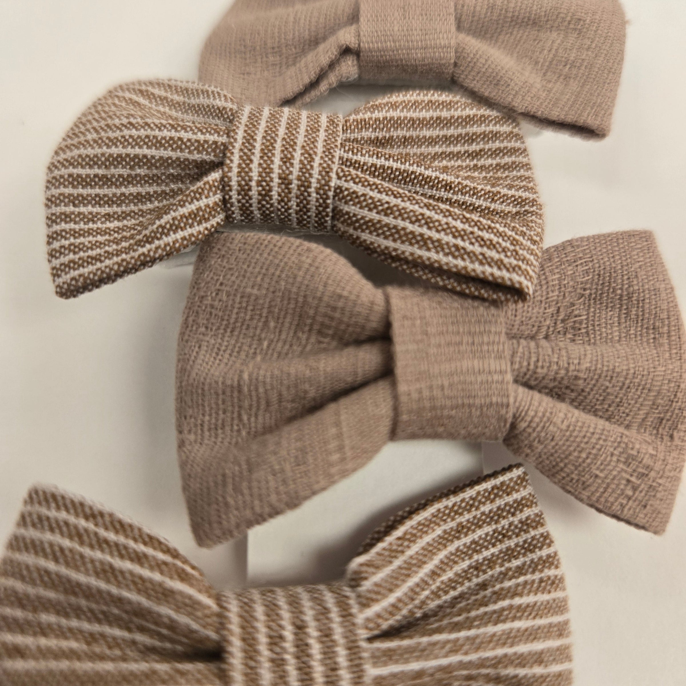 Three brown textured hair bows on a white background