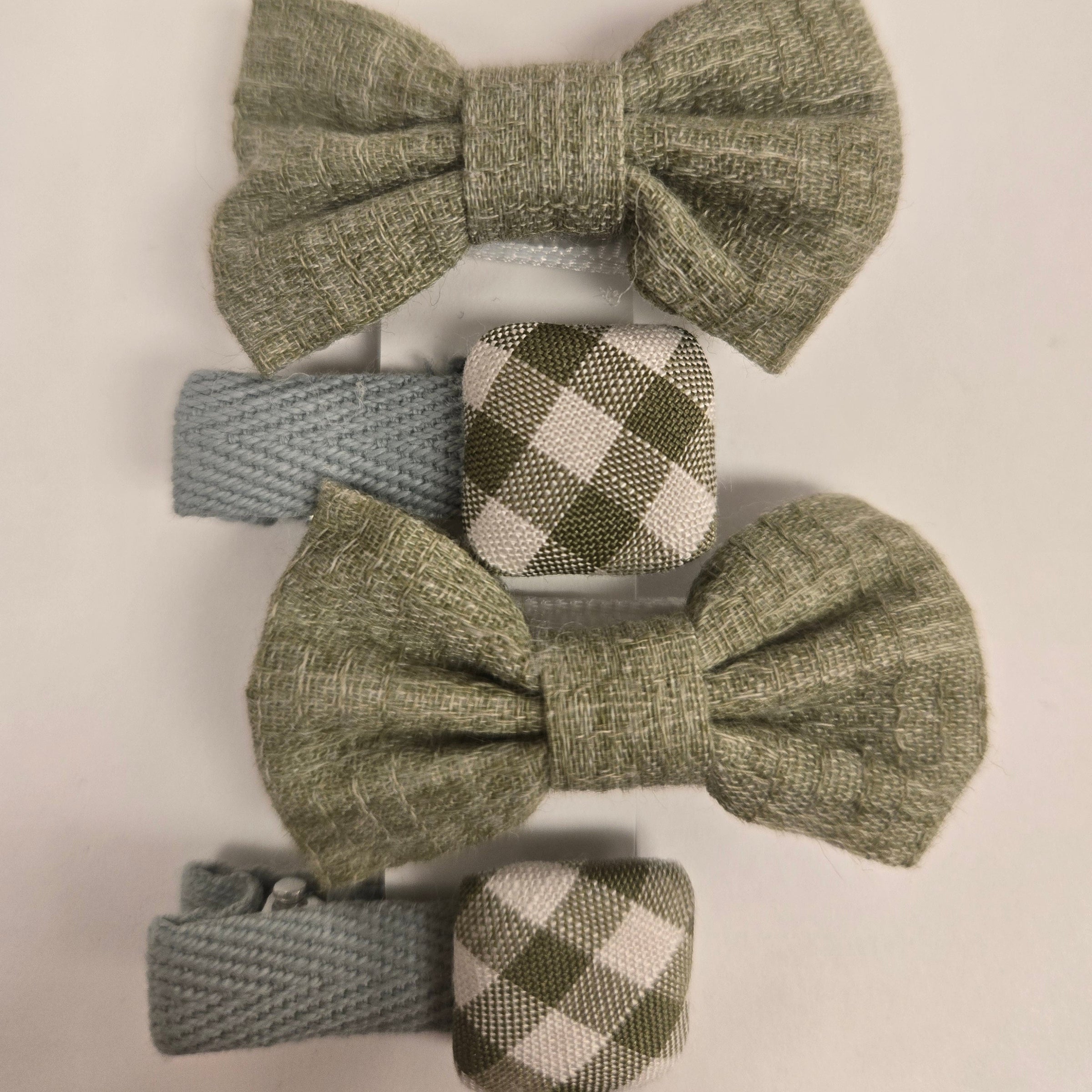 Set of green textured hair bows and checkered clips on a light background